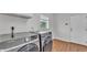 A laundry room featuring modern machines and hardwood floors at 601 Pintail Cir, Auburndale, FL 33823