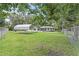 Spacious backyard with a grassy lawn, storage building, and a metal carport, enclosed by a chain-link fence at 633 Glenda St, Lakeland, FL 33805