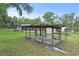 Backyard showing a dilapidated cage-like structure sitting on a concrete slab and various sheds at 633 Glenda St, Lakeland, FL 33805