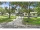 Charming fenced property featuring a single-story home, green lawn, and gravel driveway, all surrounded by mature trees at 633 Glenda St, Lakeland, FL 33805