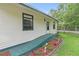 Charming home exterior with manicured flower bed, and a green ramp leading to the front door at 633 Glenda St, Lakeland, FL 33805