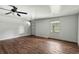 Living room boasts stylish faux wood floors, ceiling fan, and window at 633 Glenda St, Lakeland, FL 33805