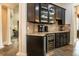 Wet bar featuring dark cabinets, granite countertop, wine cooler, and decorative backsplash tiles at 6357 Ashley Dr, Lakeland, FL 33813