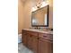 Well-lit bathroom with granite countertop vanity, wood cabinets and tiled floor for a modern, clean aesthetic at 6357 Ashley Dr, Lakeland, FL 33813