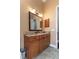 Well-lit bathroom with granite countertop vanity, wood cabinets and tiled floor for a modern, clean aesthetic at 6357 Ashley Dr, Lakeland, FL 33813