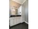 Elegant bathroom featuring a white vanity with a black countertop and modern cabinet storage at 6357 Ashley Dr, Lakeland, FL 33813