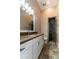 Neutral bathroom featuring a granite countertop, tiled floors, and a glass-door shower at 6357 Ashley Dr, Lakeland, FL 33813