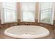 An elegant bathtub surrounded by tile with three large bright windows at 6357 Ashley Dr, Lakeland, FL 33813