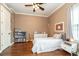 Cozy bedroom featuring hardwood floors, a ceiling fan, and a comfy bed with a neutral color palette at 6357 Ashley Dr, Lakeland, FL 33813