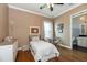 Bedroom featuring hardwood floors, a ceiling fan, and a bed near an ensuite bath at 6357 Ashley Dr, Lakeland, FL 33813