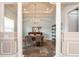 Bright dining room with chandelier, columns, wainscoting, and view of serving area with shelving at 6357 Ashley Dr, Lakeland, FL 33813
