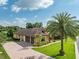 Stunning single-Gathering home featuring a spacious driveway and a lush, manicured lawn with mature palm trees at 6357 Ashley Dr, Lakeland, FL 33813