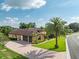 Stunning single-Gathering home featuring a spacious driveway and a lush, manicured lawn with mature palm trees at 6357 Ashley Dr, Lakeland, FL 33813
