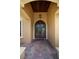 Covered front entrance features an arched wood door with decorative metalwork and brick paving at 6357 Ashley Dr, Lakeland, FL 33813