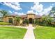 Inviting home with manicured lawn and beautiful landscaping, featuring a brick walkway to the front door at 6357 Ashley Dr, Lakeland, FL 33813