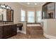 A main bathroom featuring a soaking tub, tiled floors, granite countertops, and a glass shower at 6357 Ashley Dr, Lakeland, FL 33813
