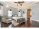 Spacious main bedroom featuring hardwood floors, a tray ceiling, and an ensuite bath entrance at 6357 Ashley Dr, Lakeland, FL 33813