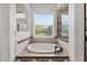 Bathroom featuring a drop-in bathtub with tile surround, separate shower, and large window at 6542 Eagle Ridge Way, Lakeland, FL 33813