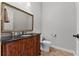 Powder room featuring a decorative wood vanity with dark countertop and gold trimmed mirror at 6542 Eagle Ridge Way, Lakeland, FL 33813