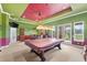 A brightly colored game room with a bar, barstools, a pool table, and a door to the outside at 6542 Eagle Ridge Way, Lakeland, FL 33813