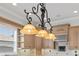 A pendant light fixture with bell shades highlights the tan cabinets and granite countertops of the kitchen at 6542 Eagle Ridge Way, Lakeland, FL 33813