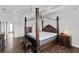 Spacious bedroom featuring a dark wood four-poster bed with an upholstered headboard and wood floors at 6542 Eagle Ridge Way, Lakeland, FL 33813