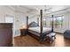Spacious bedroom featuring a dark wood four-poster bed with an upholstered headboard and wood floors at 6542 Eagle Ridge Way, Lakeland, FL 33813