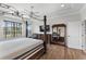 Bedroom showcasing a dark wood four-poster bed, hardwood floors, and natural lighting at 6542 Eagle Ridge Way, Lakeland, FL 33813