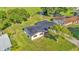 Aerial view of house featuring metal roof, manicured lawn and mature landscaping at 6543 Tula Ln, Lakeland, FL 33809
