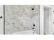Modern bathroom featuring marble tile shower with a bathtub and matte black hardware at 6543 Tula Ln, Lakeland, FL 33809