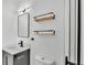 Modern bathroom with floating shelves, new light fixture, black hardware, and a glass-enclosed shower at 6543 Tula Ln, Lakeland, FL 33809