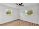 Bright bedroom with ceiling fan, wood floors, and large window with natural light at 6543 Tula Ln, Lakeland, FL 33809