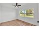 Bright bedroom with wood floors, ceiling fan, and a large window overlooking the yard at 6543 Tula Ln, Lakeland, FL 33809