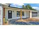 Exterior shot of home featuring covered entry, wood supports, garage and modern design at 6543 Tula Ln, Lakeland, FL 33809