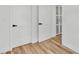 Hallway featuring white walls, wood floors, and a set of doors at 6543 Tula Ln, Lakeland, FL 33809