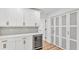 Bright kitchen features white cabinetry, marble countertops, wine fridge, and stylish glass closet doors at 6543 Tula Ln, Lakeland, FL 33809