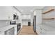 Bright kitchen featuring white cabinets, herringbone backsplash, stainless appliances, and floating wood shelves at 6543 Tula Ln, Lakeland, FL 33809