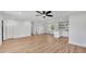 Bright living room featuring wood-look floors, a ceiling fan, and an open layout to the kitchen with breakfast bar seating at 6543 Tula Ln, Lakeland, FL 33809
