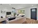 Bright living room with modern furnishings, wood floors, and a view of the front yard at 6543 Tula Ln, Lakeland, FL 33809