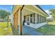 Covered porch featuring vertical wood supports and a view into an enclosed sunroom at 6543 Tula Ln, Lakeland, FL 33809