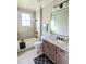 Modern bathroom featuring a granite vanity, toilet, shower-tub, and decorative mirror at 7919 Lake James Blvd, Lakeland, FL 33810