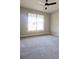 Bright bedroom featuring neutral carpet, walls, and a large sunny window at 7919 Lake James Blvd, Lakeland, FL 33810