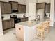 Modern kitchen featuring granite countertops, stainless steel appliances, and a central island with bar stool seating at 7919 Lake James Blvd, Lakeland, FL 33810