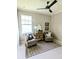 Neutral sitting room featuring two chairs, a table, art and a plaid rug at 7919 Lake James Blvd, Lakeland, FL 33810