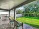 Scenic backyard featuring a well-manicured lawn, lush trees, and a covered patio with seating at 13525 Gorgona Isle Dr, Windermere, FL 34786