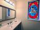 Bright bathroom featuring a single sink vanity and a unique Mickey Mouse stained glass window at 13525 Gorgona Isle Dr, Windermere, FL 34786