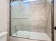 Bathtub shower with a glass door and tiled wall at 13525 Gorgona Isle Dr, Windermere, FL 34786