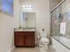 Bathroom featuring a wooden vanity with granite countertop and shower with glass door at 13525 Gorgona Isle Dr, Windermere, FL 34786