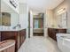 Bright bathroom with dual vanities, neutral-toned flooring, and access to a bedroom at 13525 Gorgona Isle Dr, Windermere, FL 34786
