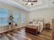 Spacious bedroom with tray ceilings, beautiful flooring, and natural light at 13525 Gorgona Isle Dr, Windermere, FL 34786